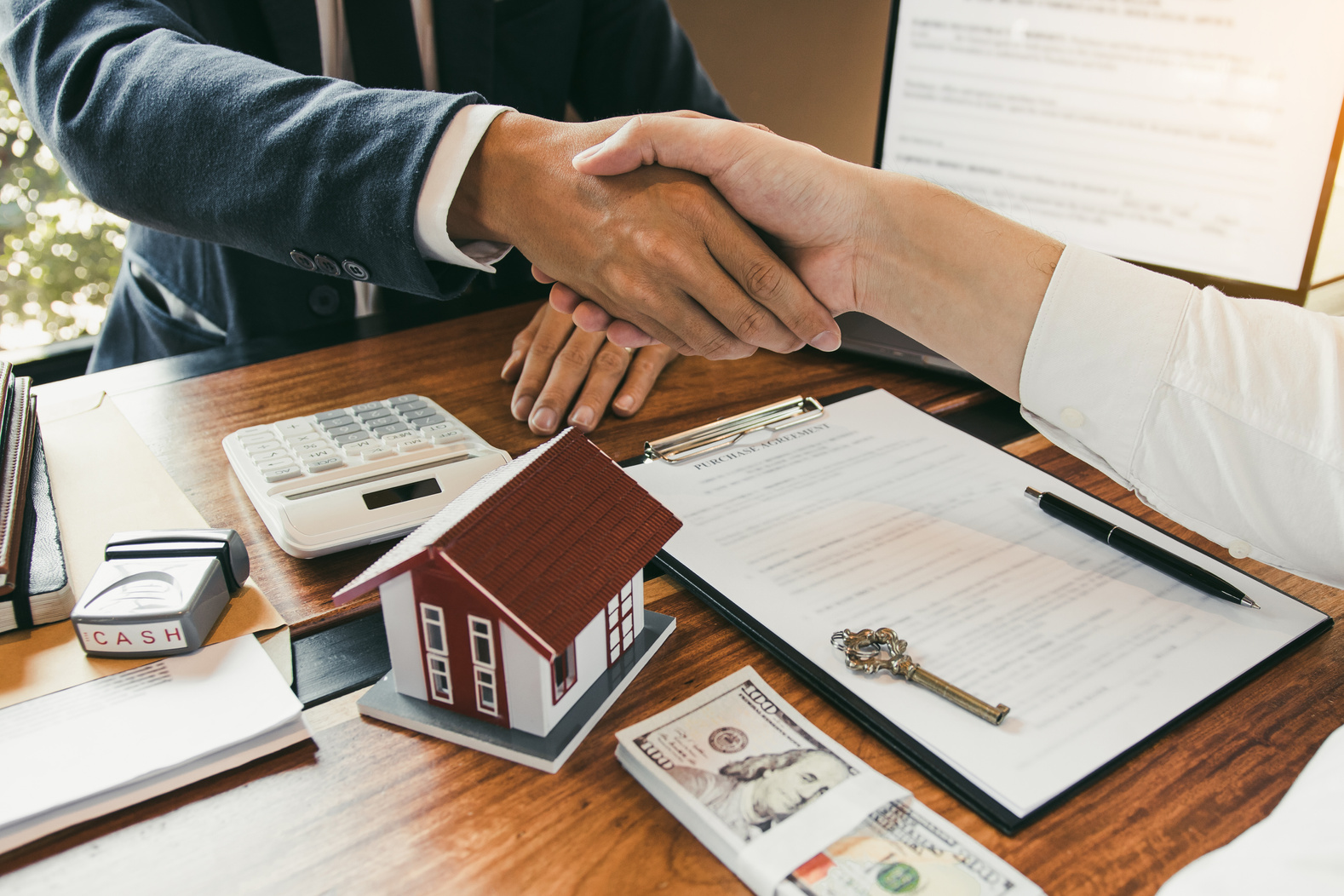 Home Sales Agents and Buyer Shake Hands after Deal